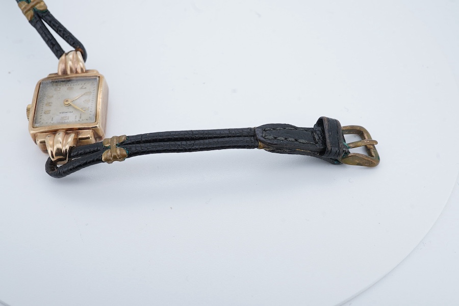 A lady's 9ct gold Primula manual wind wrist watch, with fluted lugs, on a leather strap. Condition - fair